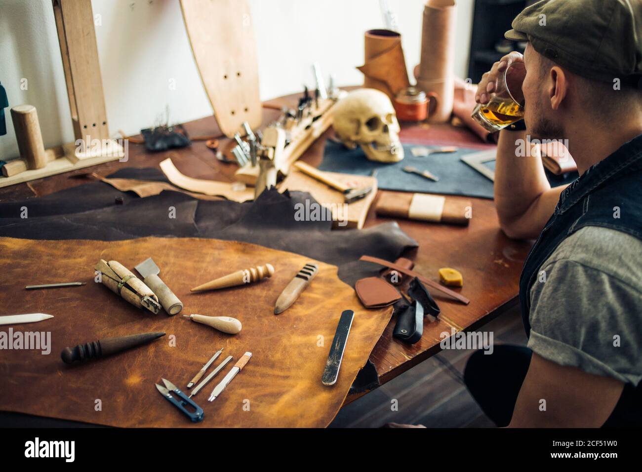 Proceso de trabajo de la cartera de cuero en el taller de cuero. Hombre  sosteniendo herramienta de artesanía y regla de hierro Fotografía de stock  - Alamy