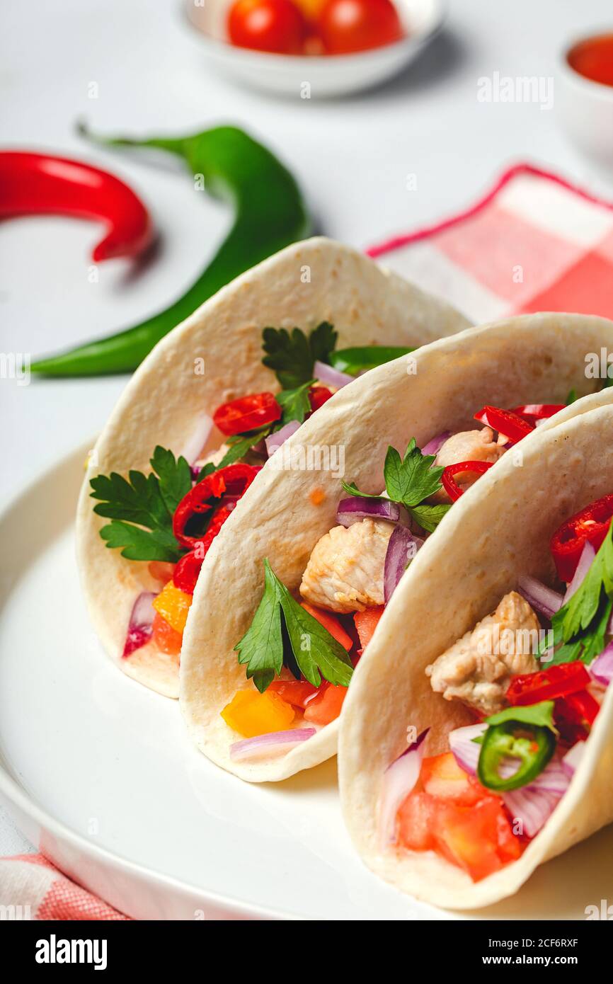 Tacos mexicanos caseros con verduras frescas y pollo sobre fondo blanco