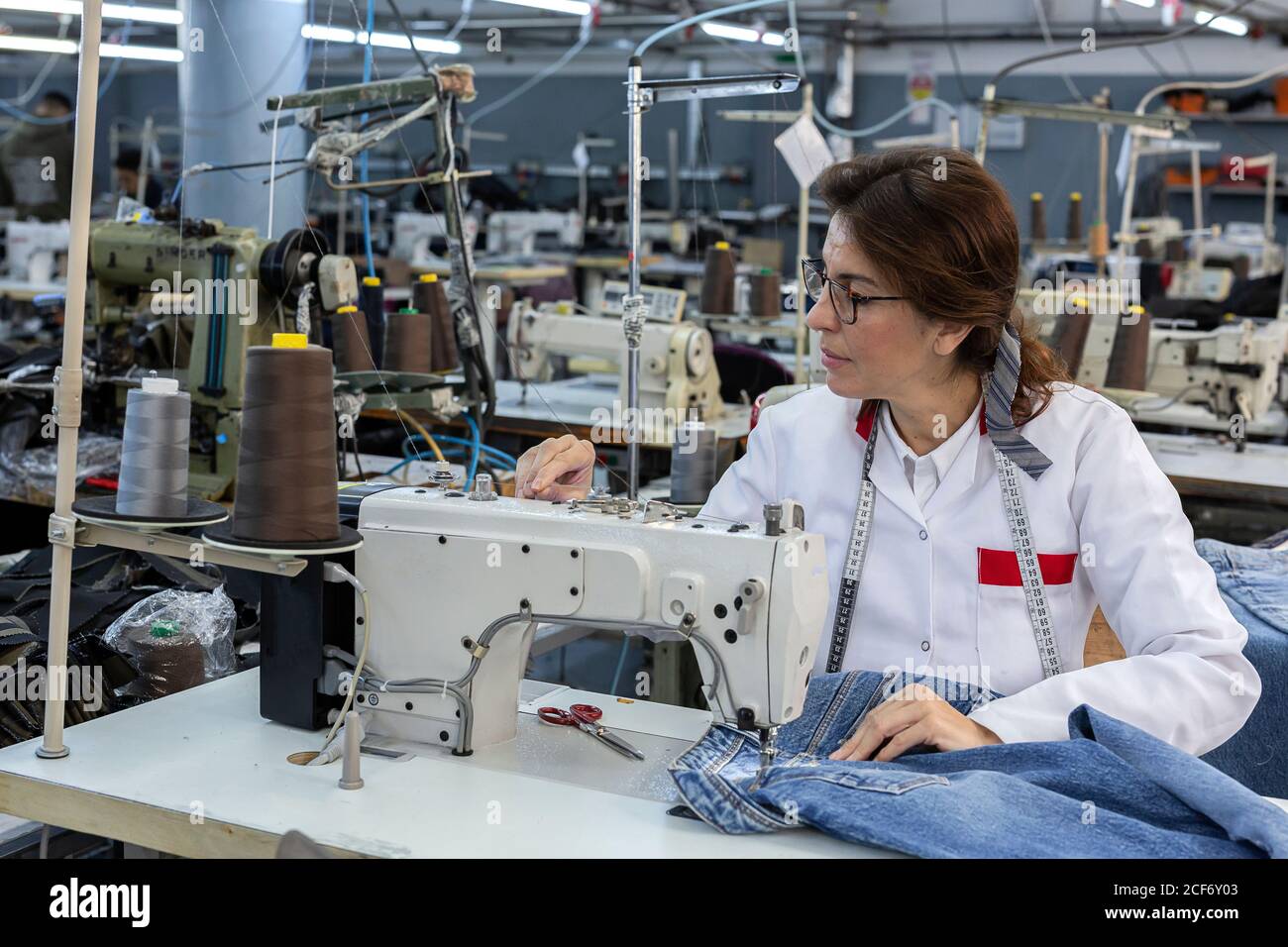 Mujer trabajadora manos en fábrica textil coser en máquina de coser  industrial. Producción industrial Fotografía de stock - Alamy