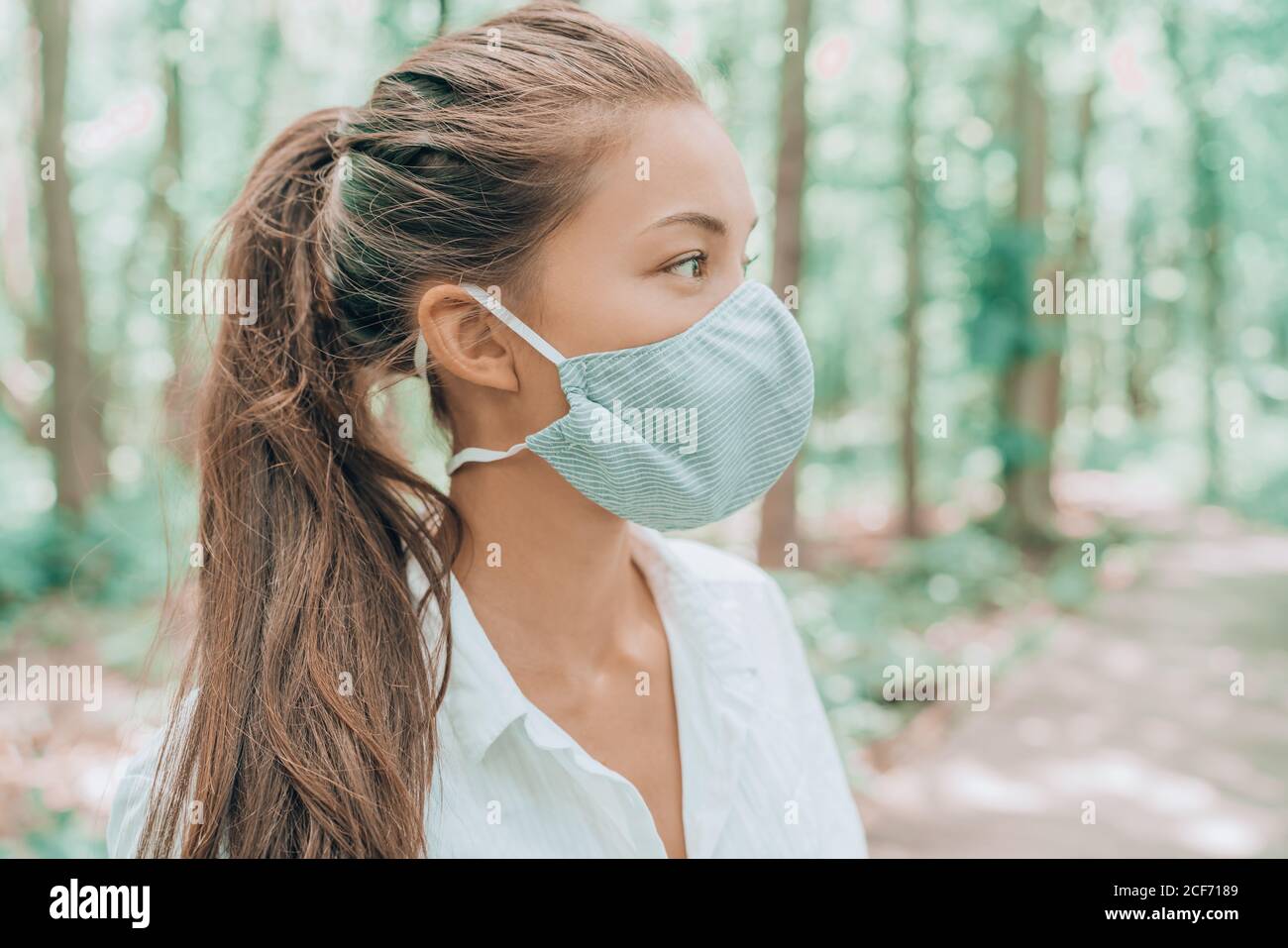 Mascarilla facial de tejido de algodón transpirable para la piel. Mujer  asiática que lleva la boca del virus corona que cubre caminar al aire libre  en bosques Fotografía de stock - Alamy