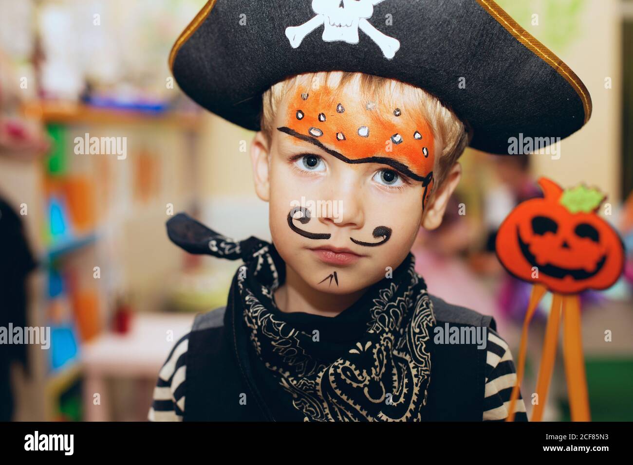 Fiesta de Halloween. Un niño pequeño con un traje pirata y un maquillaje en  su cara está pasando un buen rato en la fiesta de Halloween. Niños de la  pintura de la