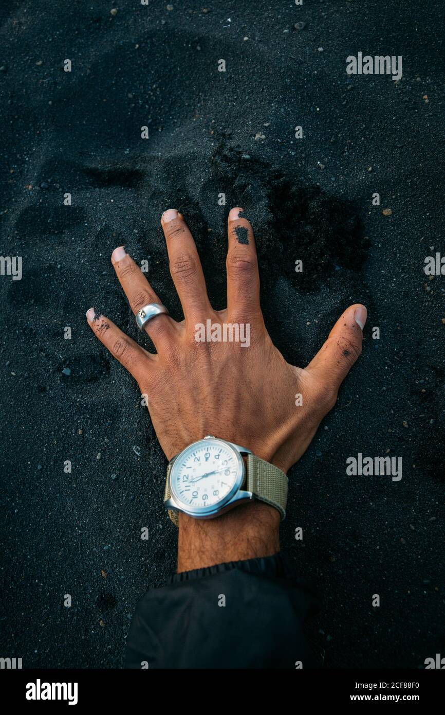 Mano de la persona de la cosecha con el reloj de mano en la pila grande De  arena negra en Islandia Fotografía de stock - Alamy