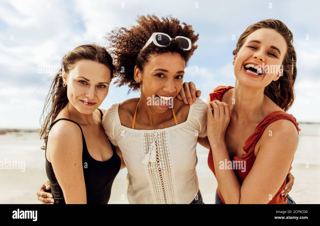 Cerca de tres amigas que disfrutan de sus vacaciones. Amigos multiétnicos en vacaciones divertirse al aire libre. Foto de stock