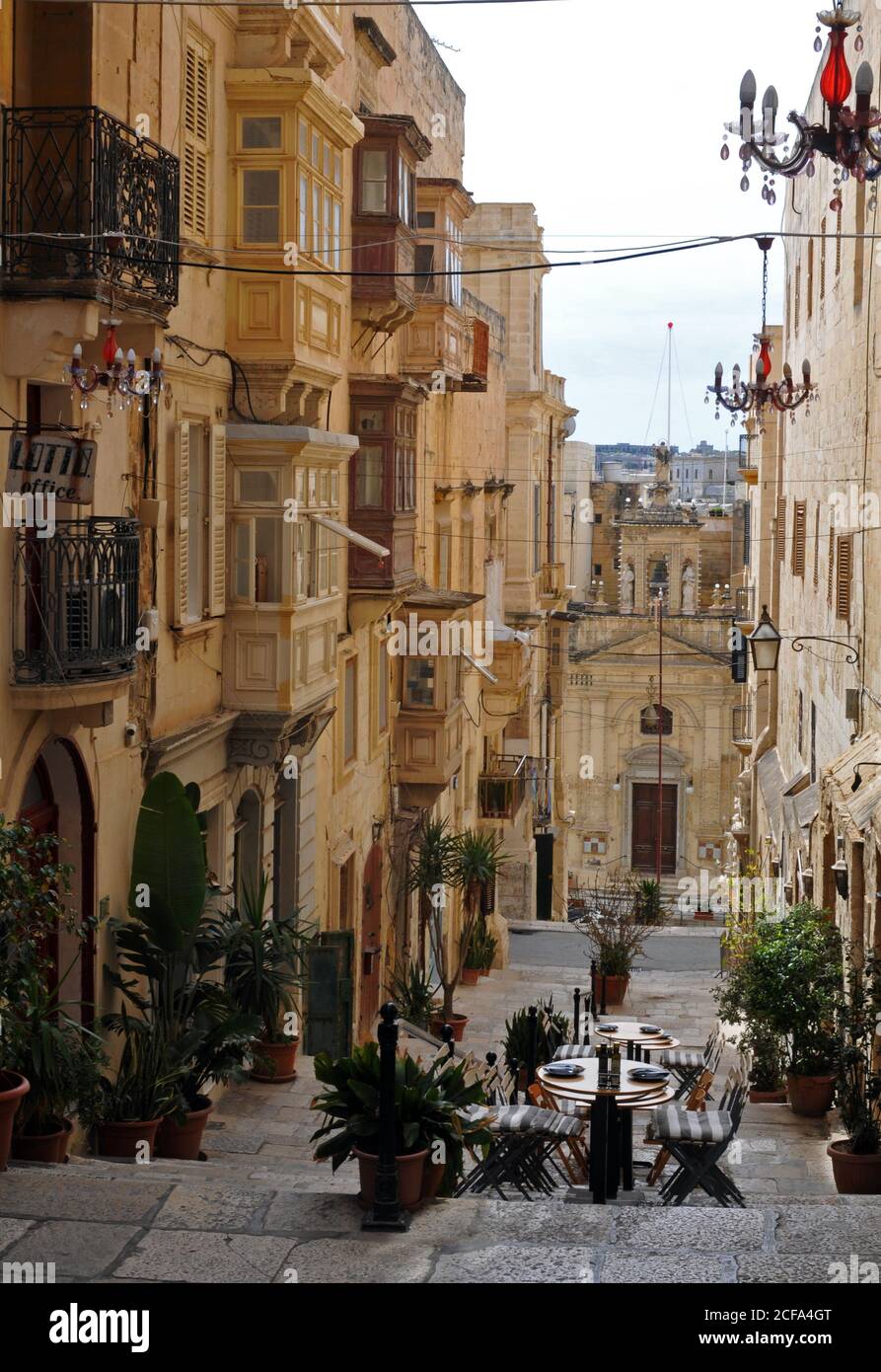 La histórica Iglesia de Santa Lucía se encuentra a los pies de una sección peatonal de la calle Santa Lucía bordeada de tiendas y restaurantes en Valletta, Malta. Foto de stock