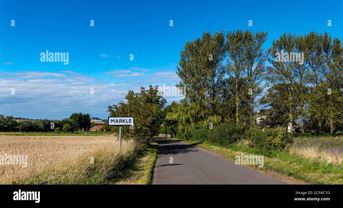 Tranquila carretera de campo vacía con la señal del pueblo, Markle, East Lothian, Escocia, Reino Unido Foto de stock