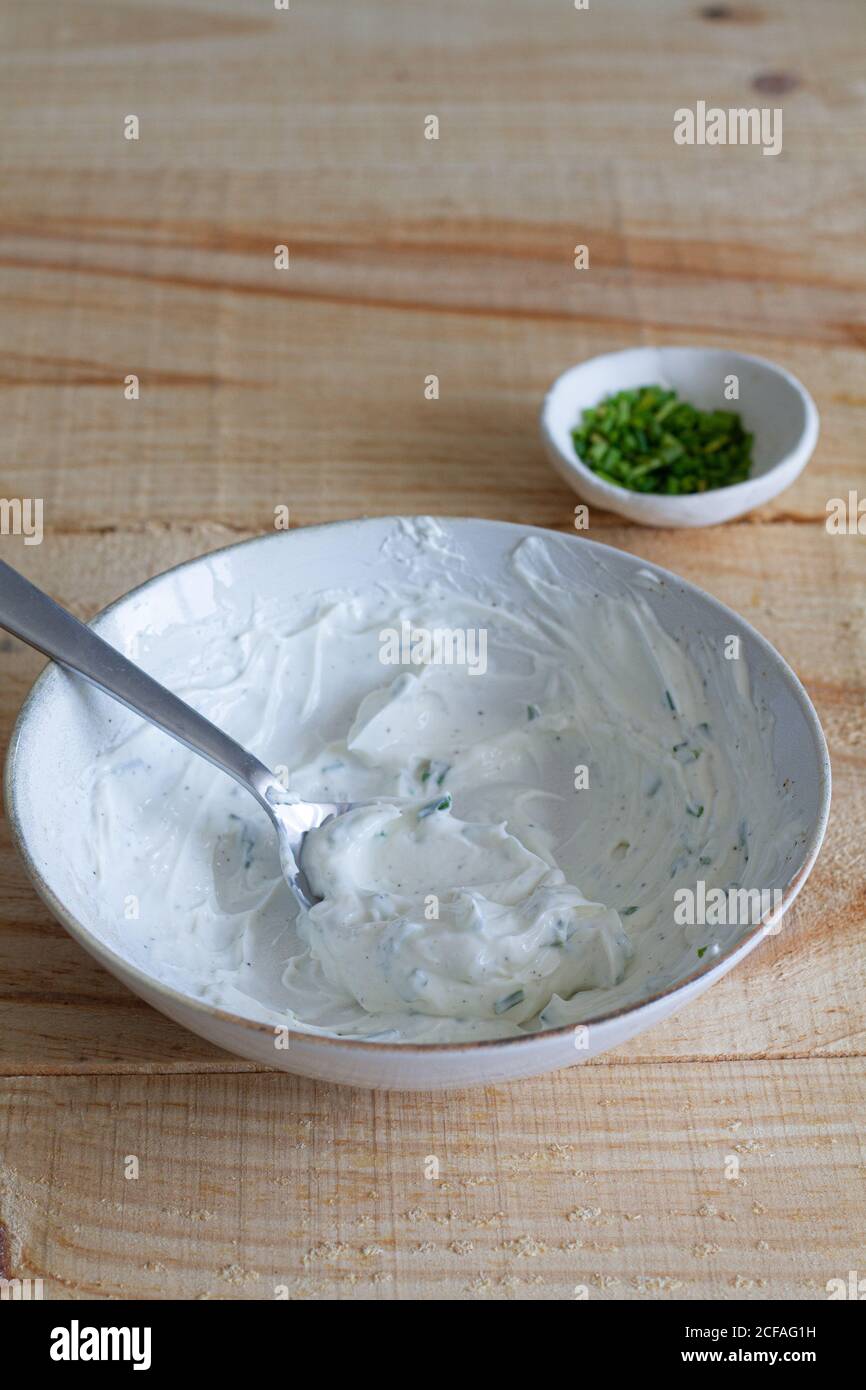 Gran ángulo de salsa sabrosa hecha de crema agria y.. mezclado con cebolla verde picada Foto de stock