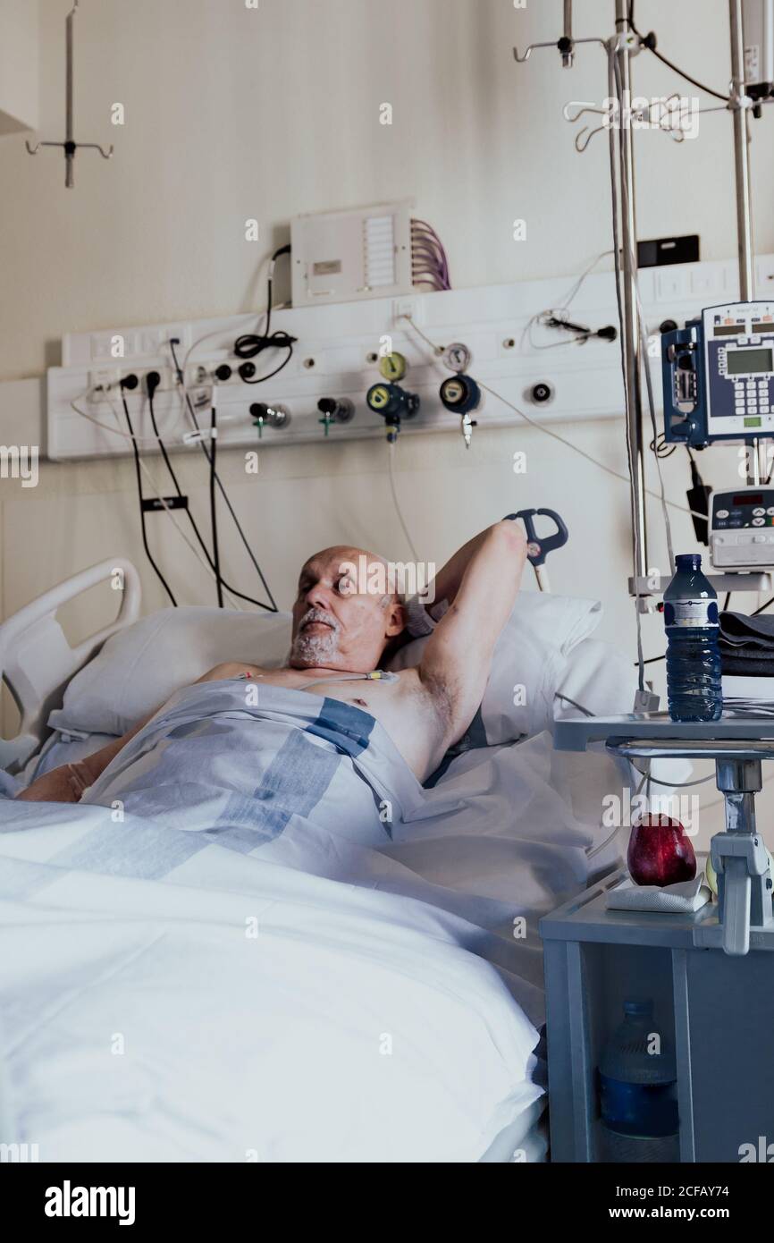 Hombre mayor ingresado en una habitación del hospital por problemas de salud Foto de stock