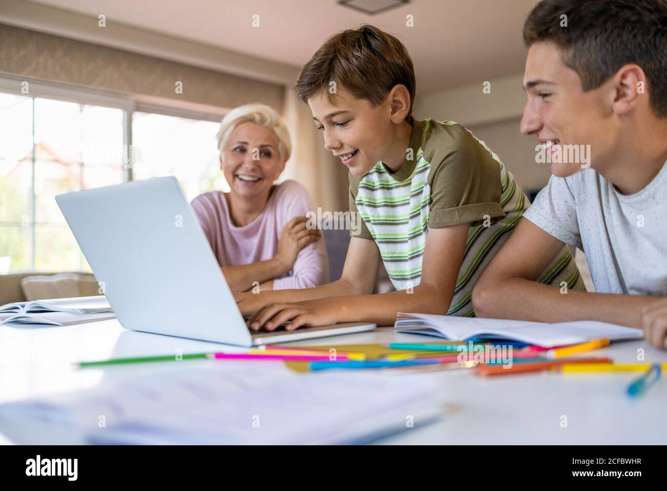 Madre ayudando a sus hijos a hacer la tarea en casa Foto de stock