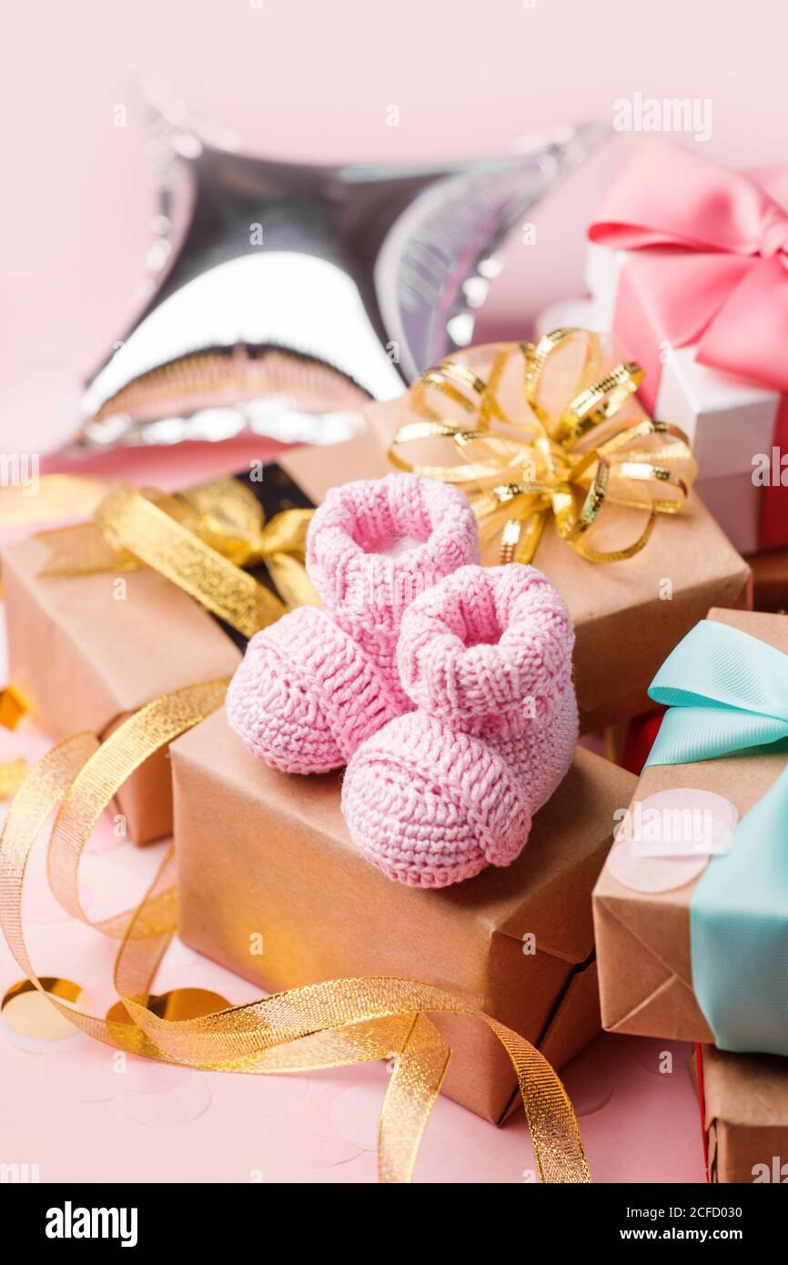 Zapatos de bebé rosa para niña en caja de regalo - concepto de primer paso, fiesta de cumpleaños, ducha de bebé, aniversario. Caja de regalo y regalo y botines Foto de stock