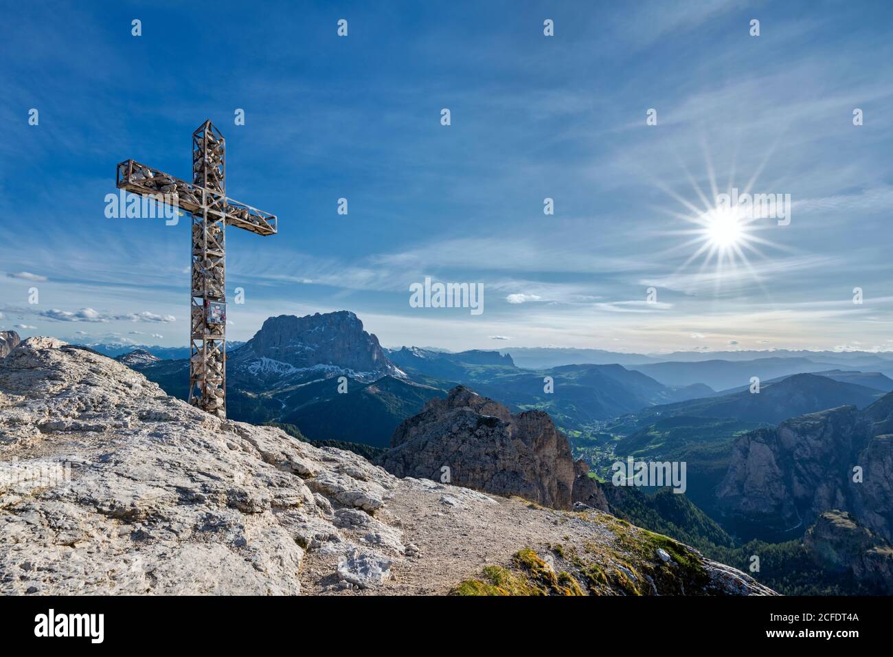 Paso Gardena, Provincia de Bolzano, Tirol del Sur, Italia. La cruz de la cumbre de la Große Cirspitze. En el fondo el Sassolungo y el Val Gardena Foto de stock