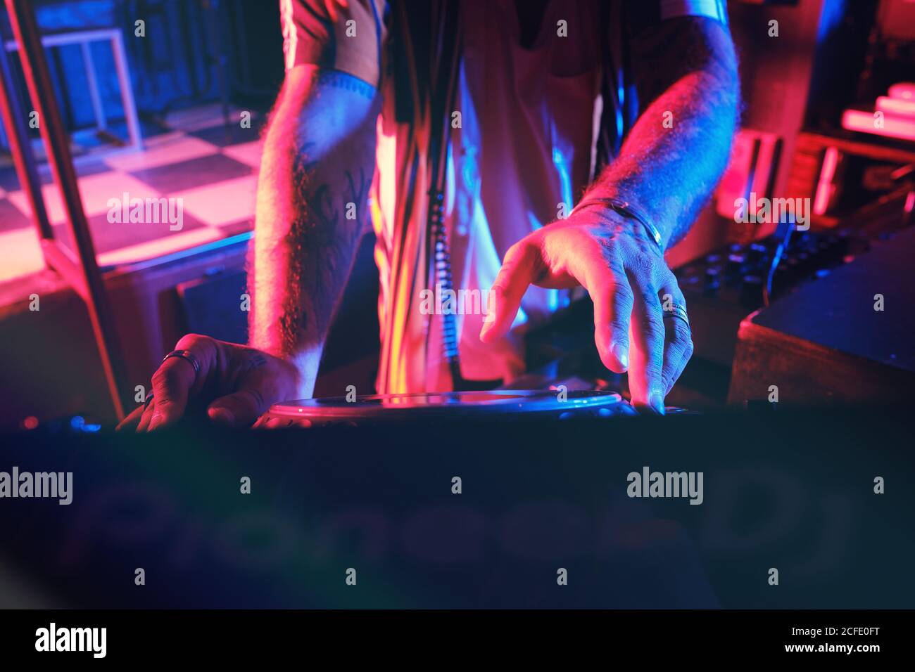 anónimo dj hombre jugando en un club con luces Foto de stock