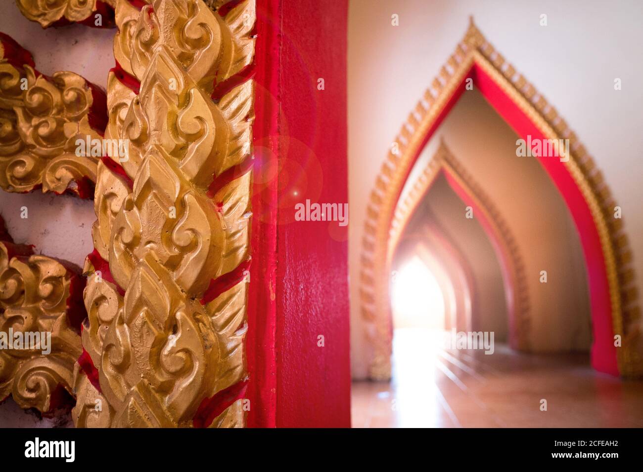 Antiguo arco en ruinas en el antiguo templo al atardecer con efecto de llamarada de lente. Detalle de la arquitectura del templo tradicional en Tailandia, Sudeste de Asia Foto de stock