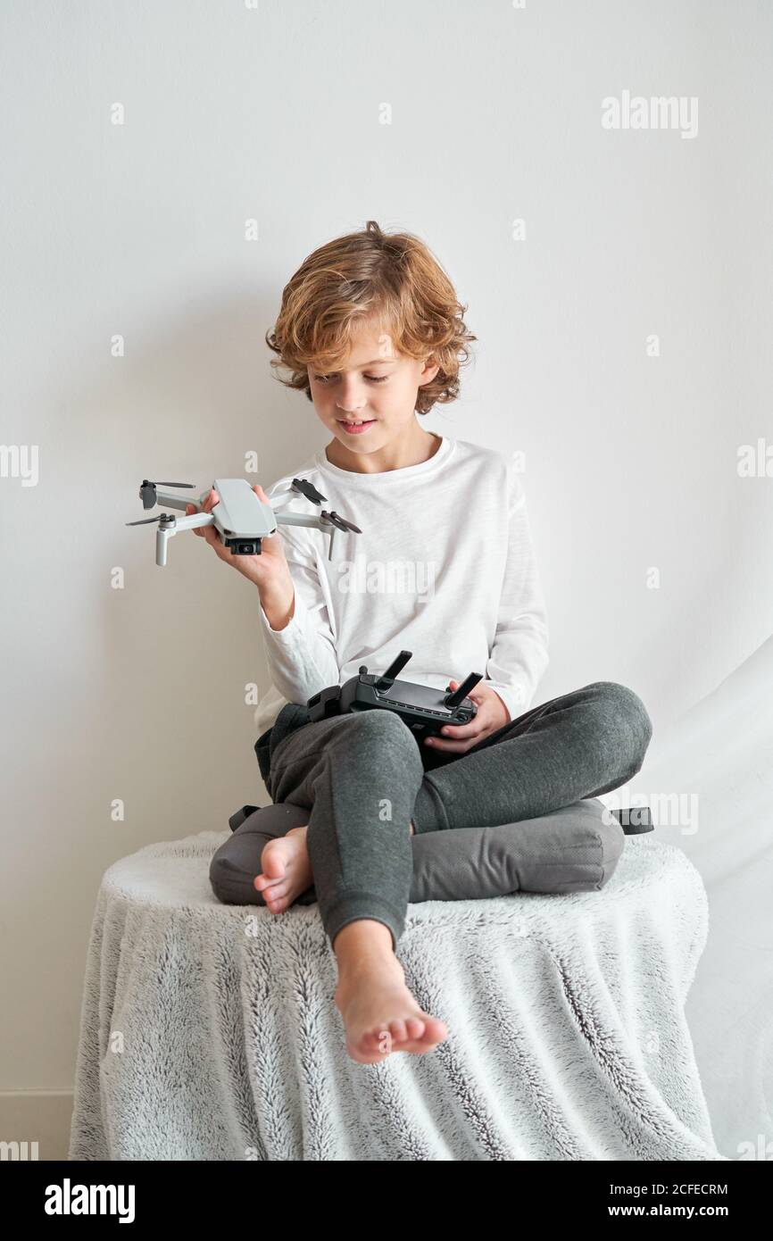 Niño manipulando un drone y el mando a distancia que acaba de dar a él Foto de stock