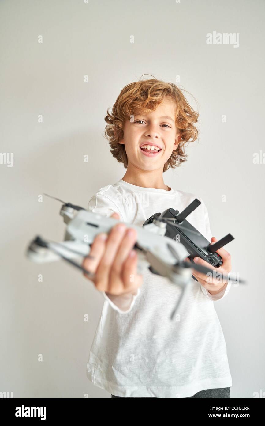 Niño manipulando un drone y el mando a distancia que acaba de dar a él Foto de stock