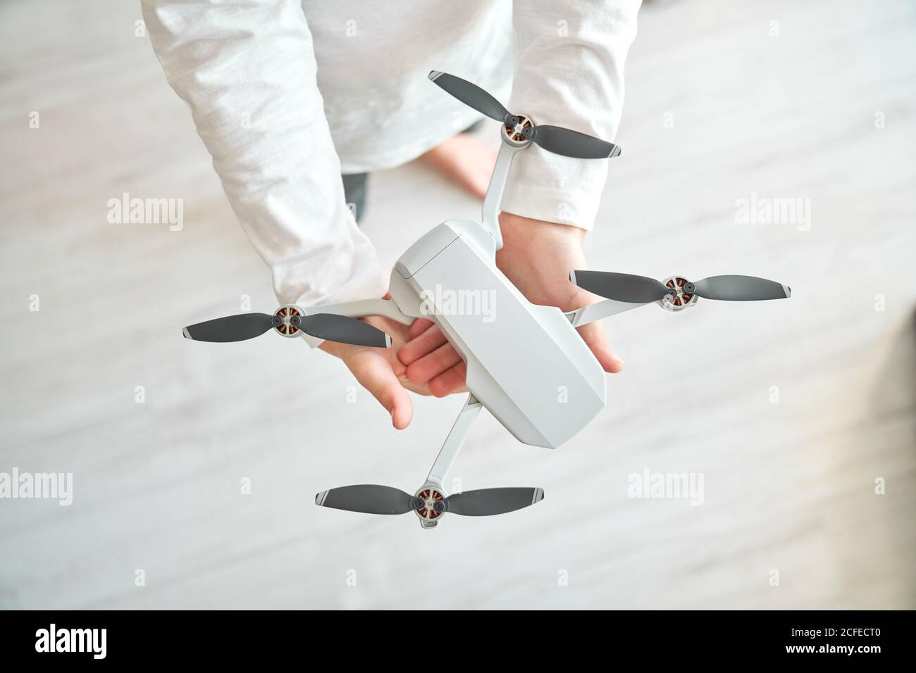 Niño manipulando un drone y el mando a distancia que acaba de dar a él Foto de stock