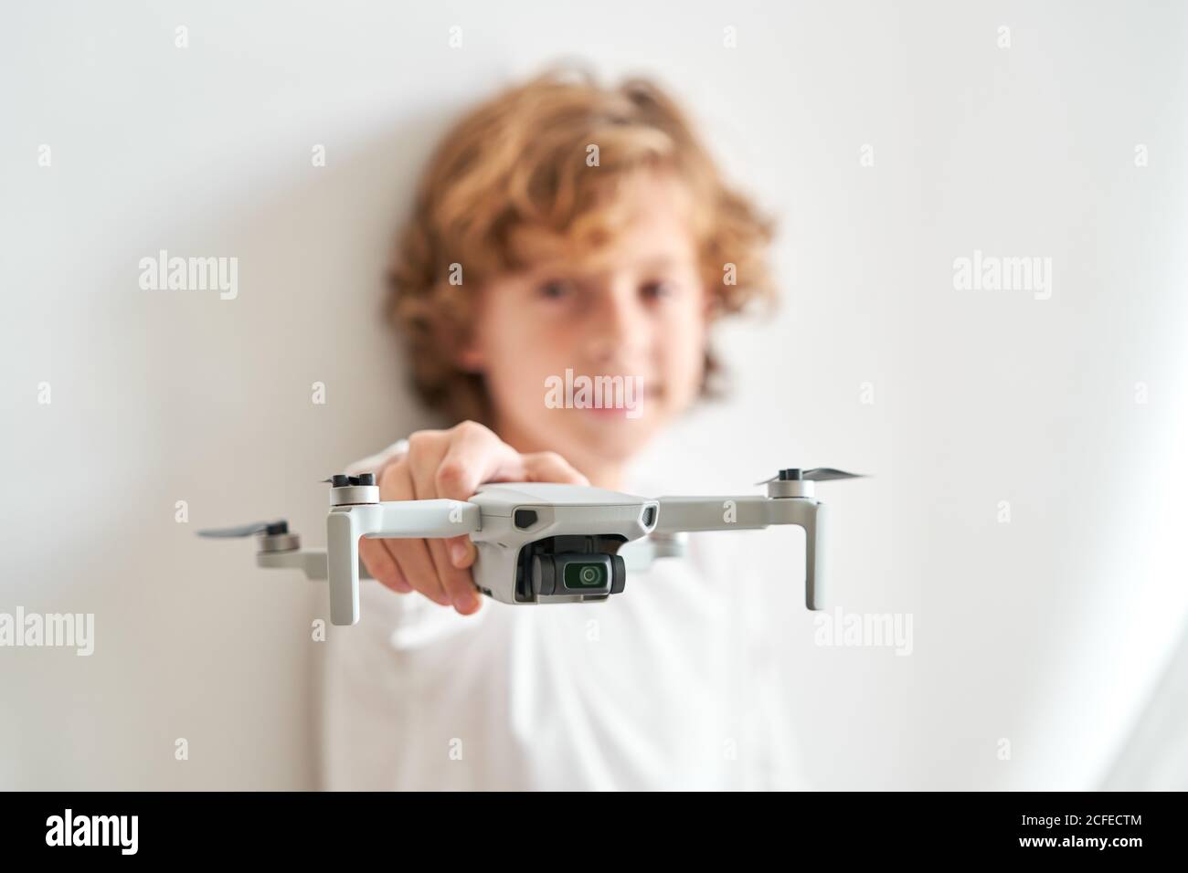 Niño manipulando un drone y el mando a distancia que acaba de dar a él Foto de stock