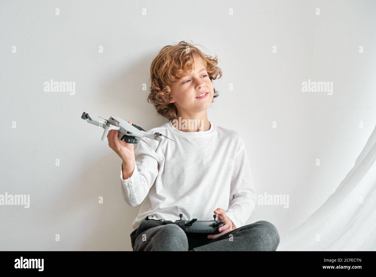 Niño manipulando un drone y el mando a distancia que acaba de dar a él Foto de stock