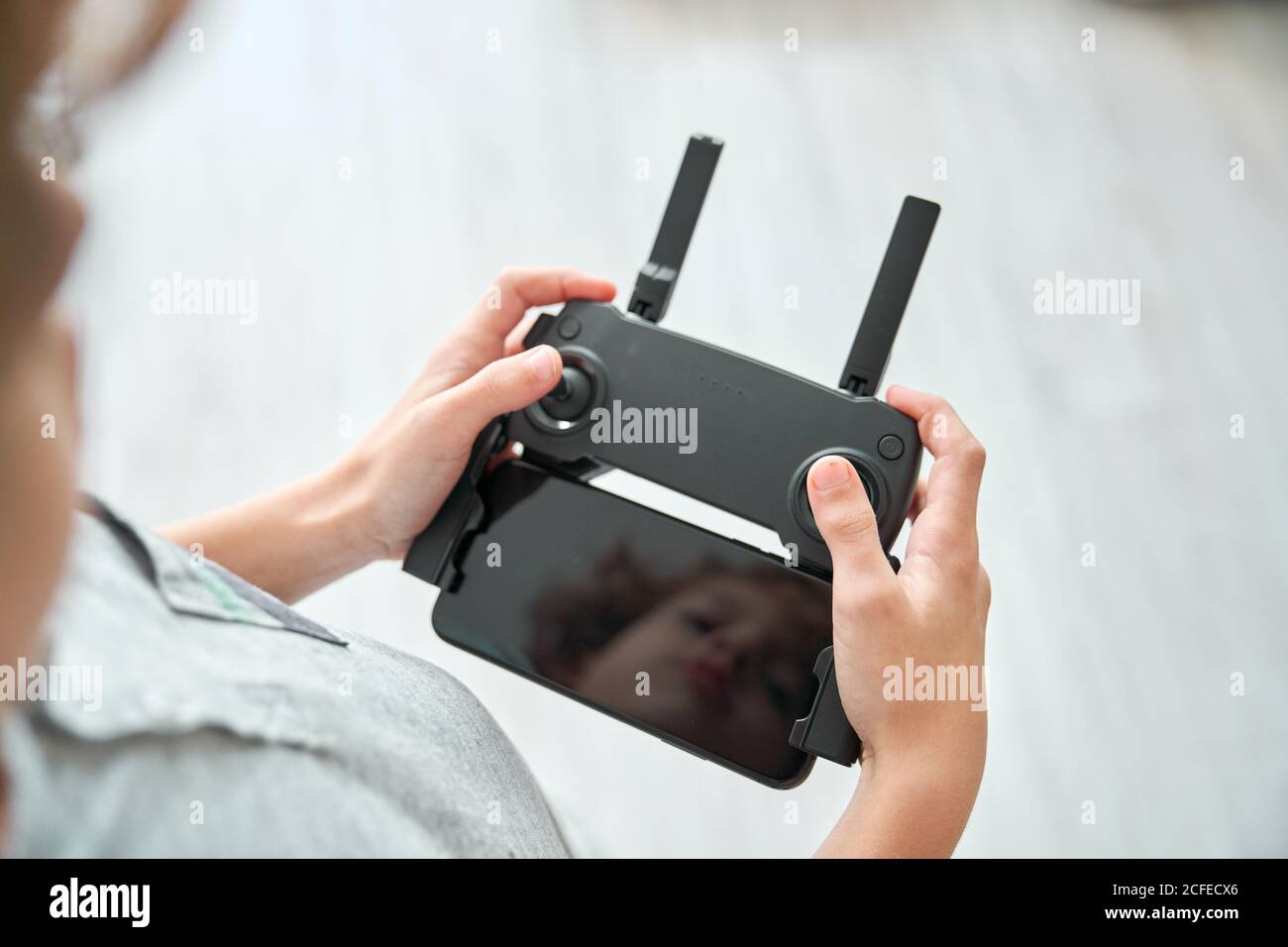 Niño manipulando un drone y el mando a distancia que acaba de dar a él Foto de stock
