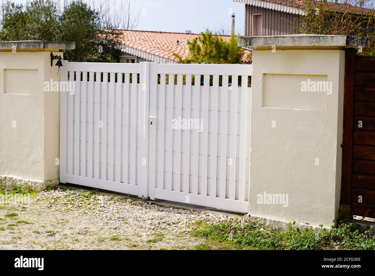 puerta de metal suburbana cerca blanca en el acceso a la calle residencial jardín de la casa Foto de stock