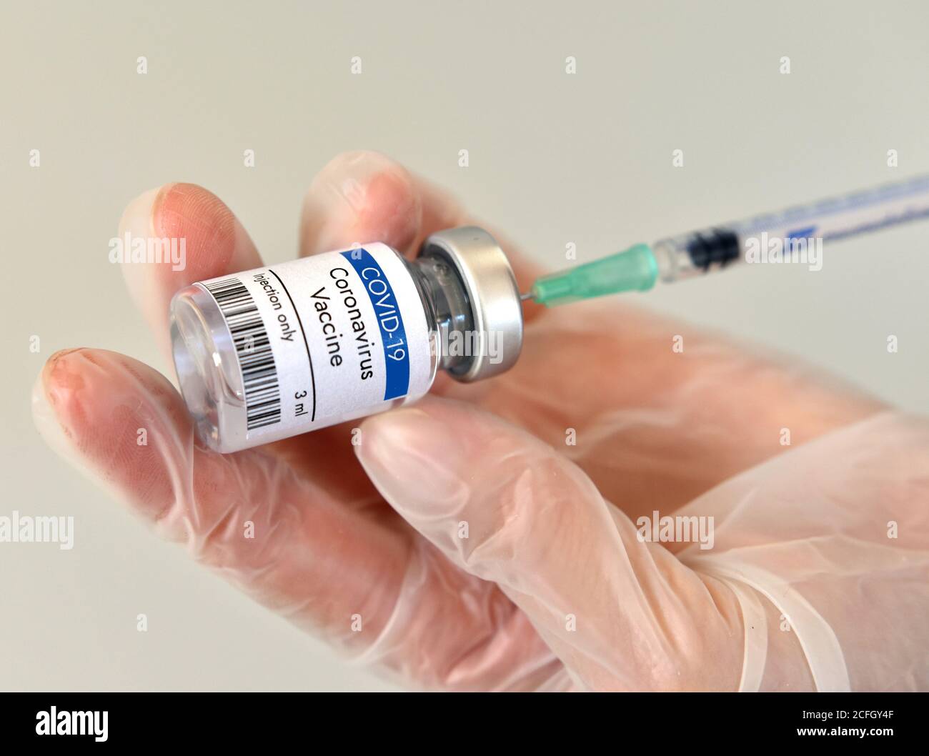 Recipiente de vial para la vacuna contra el coronavirus en la mano sobre fondo blanco. Vista de primer plano. Frasco de la vacuna contra el coronavirus. Foto de stock