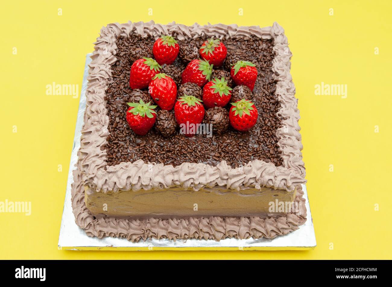 Pastel de chocolate casero cubierto con salpicaduras de chocolate y fresas  frescas. Conocido en Brasil como 