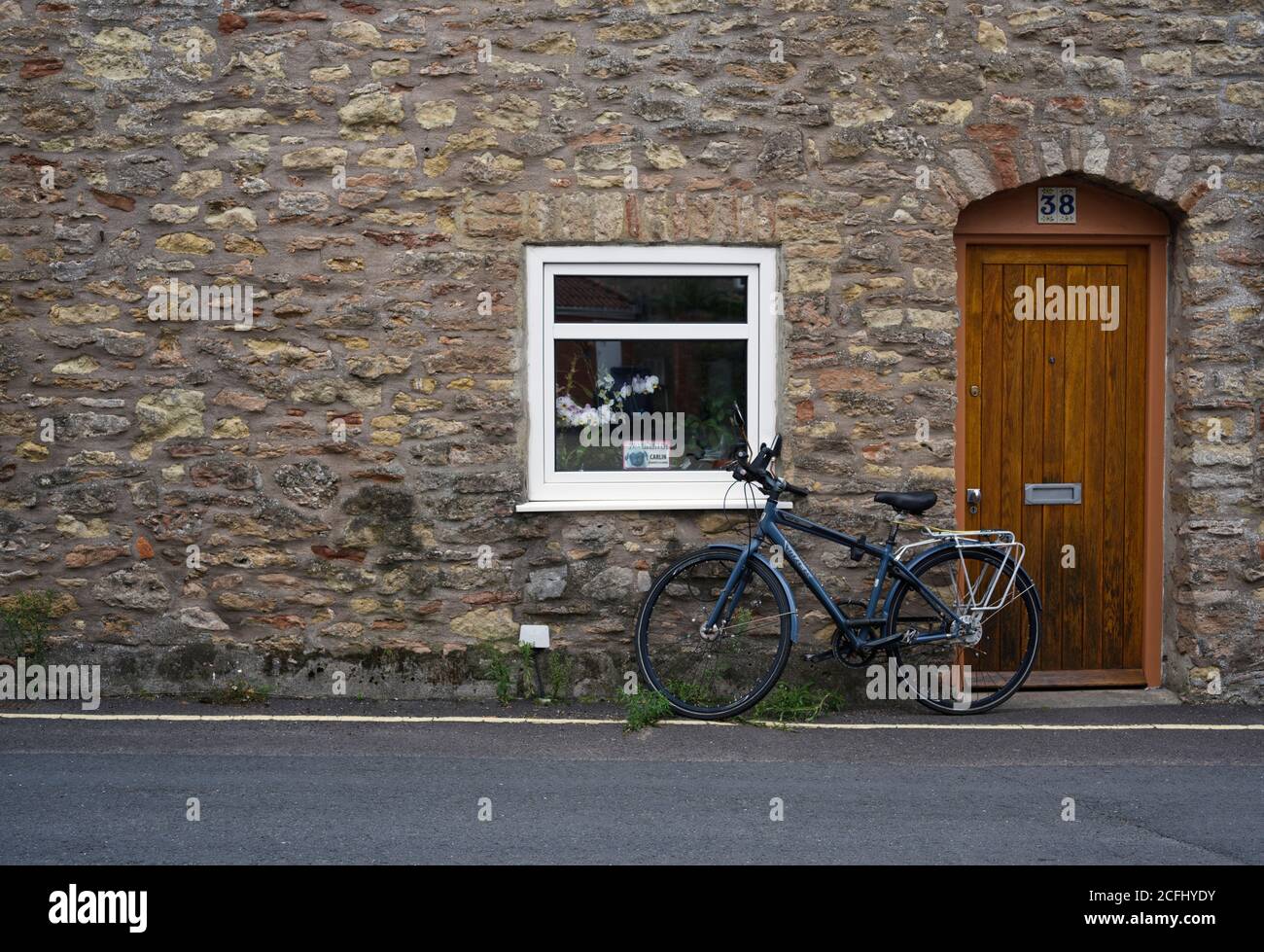 Escena con una bicicleta estacionada en una casa de campo en Wells, Somerset Foto de stock