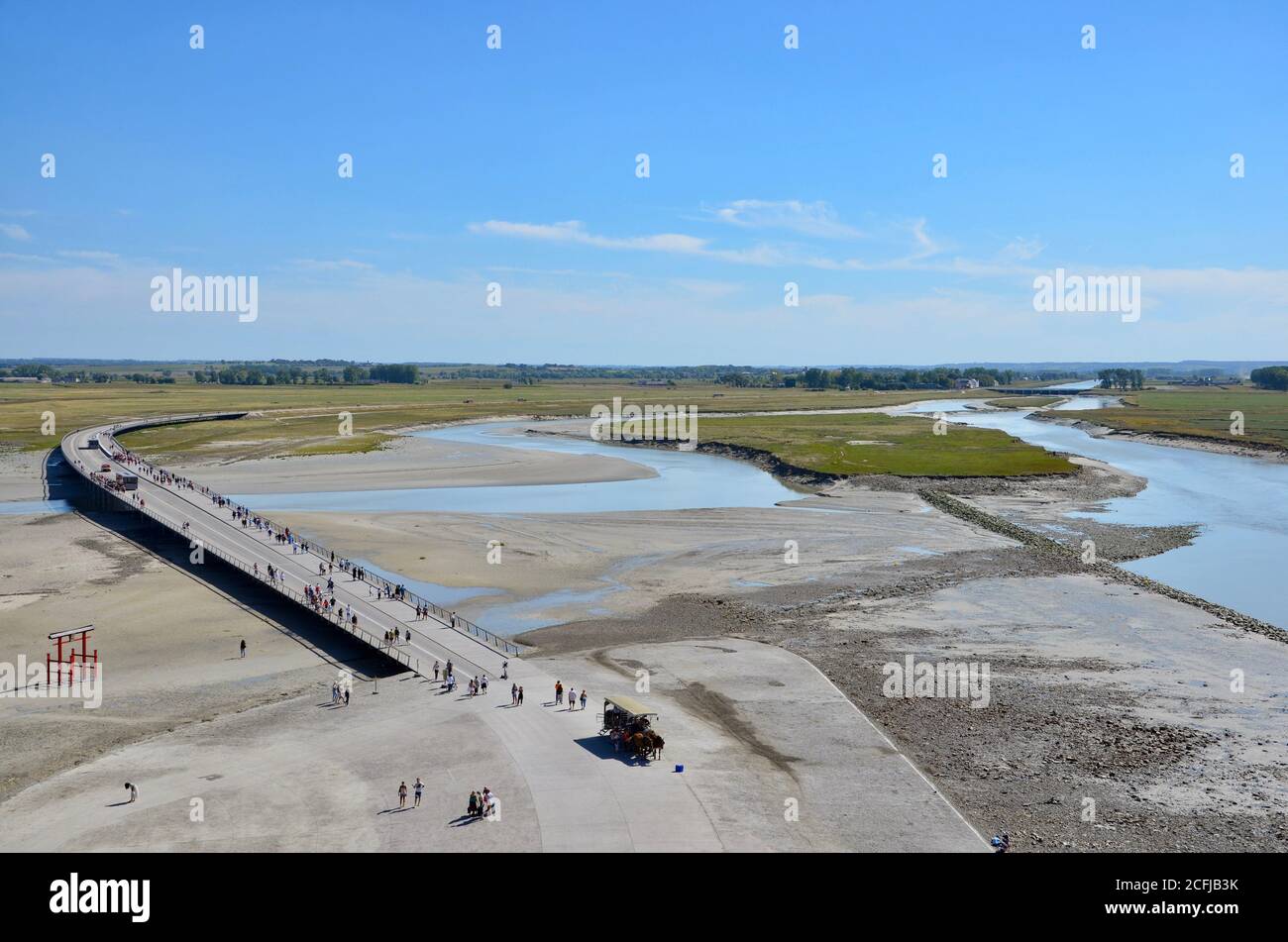Vista desde la abadía le Mont Saint-Michel en Normandía a la plana de barro y marismas de paisaje en la marea baja, Francia, Canal Inglés, la gente está cruzando Foto de stock