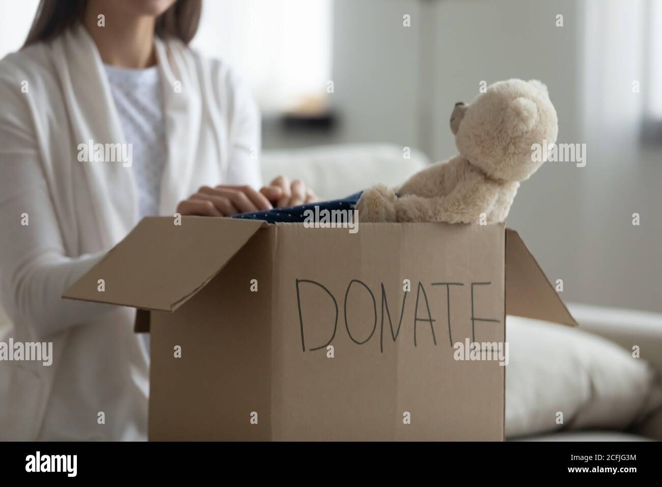Un voluntario amable puso las cosas para las familias pobres en un paquete de caridad. Foto de stock