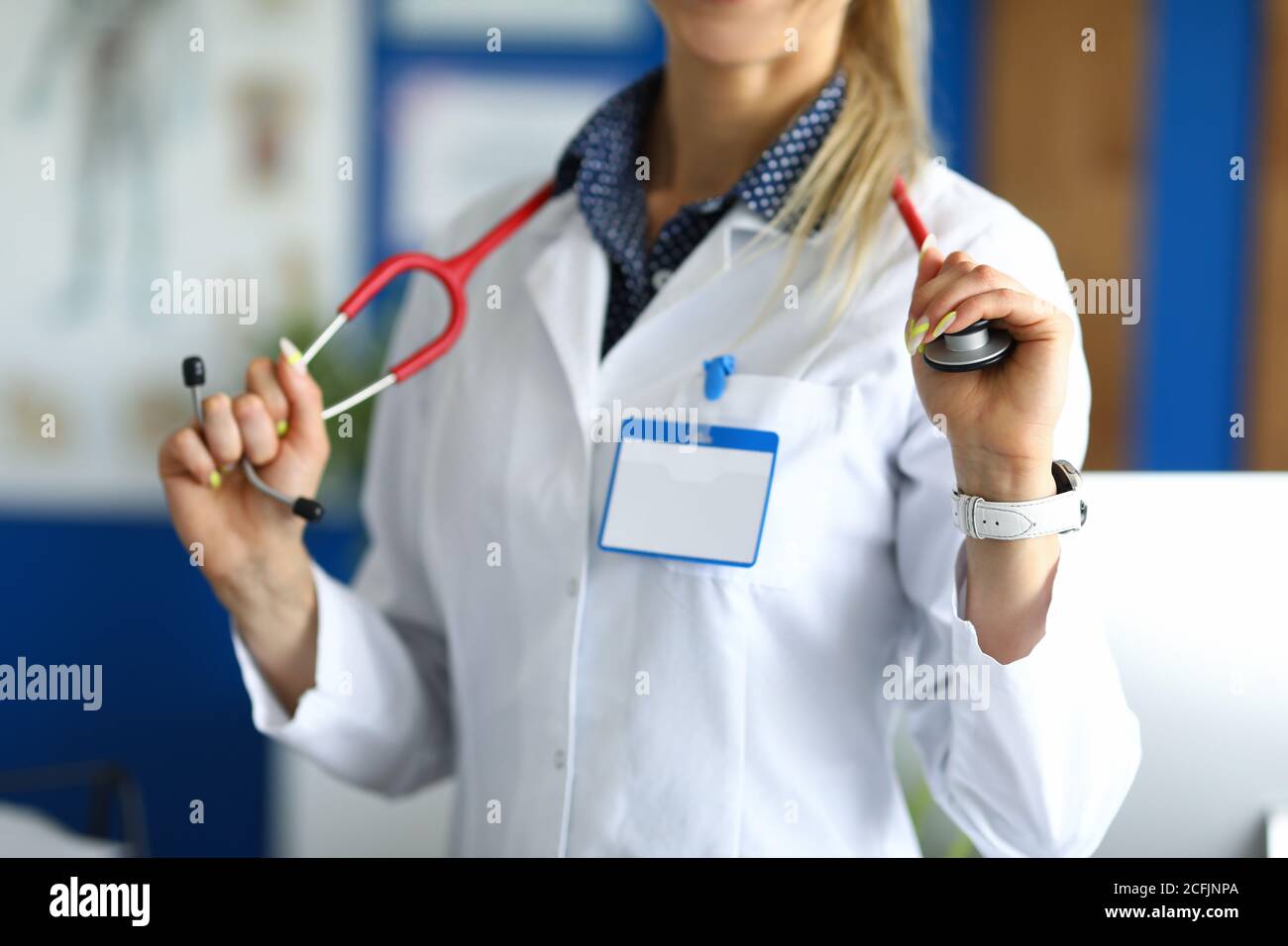Oficial médico en capa blanca sostiene estetoscopio. Foto de stock