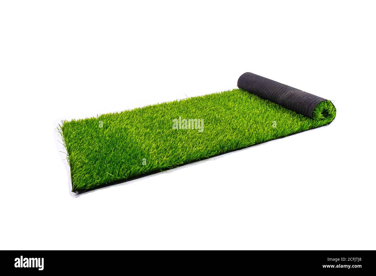 rollo con césped verde artificial aislado sobre fondo blanco, que cubre zonas de juego y zonas deportivas. Foto de stock