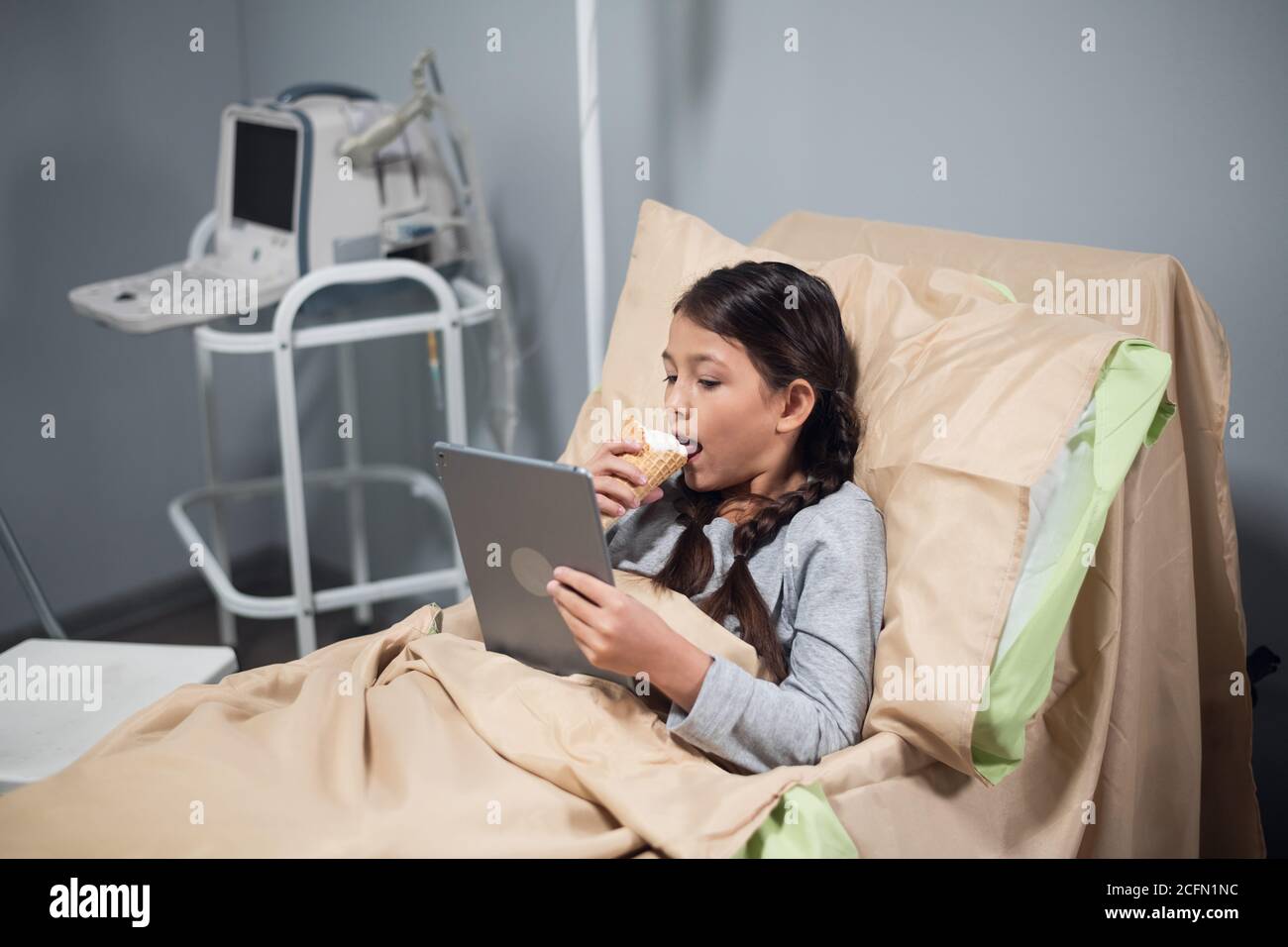Un pequeño paciente acostado en una cama de hospital con un aparato y un  helado, todo lo que un niño podría soñar Fotografía de stock - Alamy