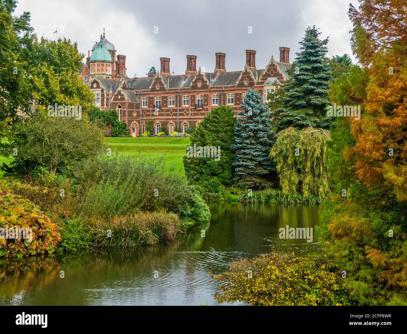 Colores otoñales en los terrenos de la casa de Sandringham, con la casa en el fondo, Norfolk, Reino Unido Foto de stock