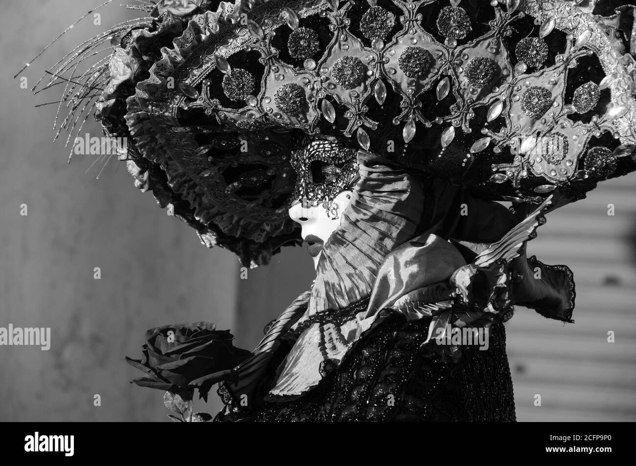 VENECIA, ITALIA - 16 DE FEBRERO de 2015: Máscara romántica con una rosa roja en la plaza de San Marcos durante el Carnaval. El Carnaval de Venecia es anual Foto de stock