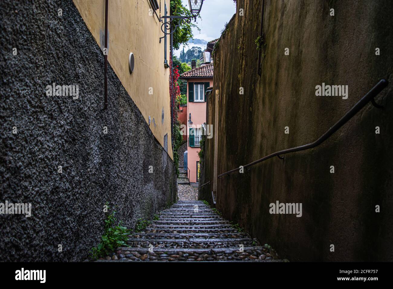 Calle muy estrecha en una pequeña ciudad en el Lago como, situado en el norte de Italia. Foto de stock