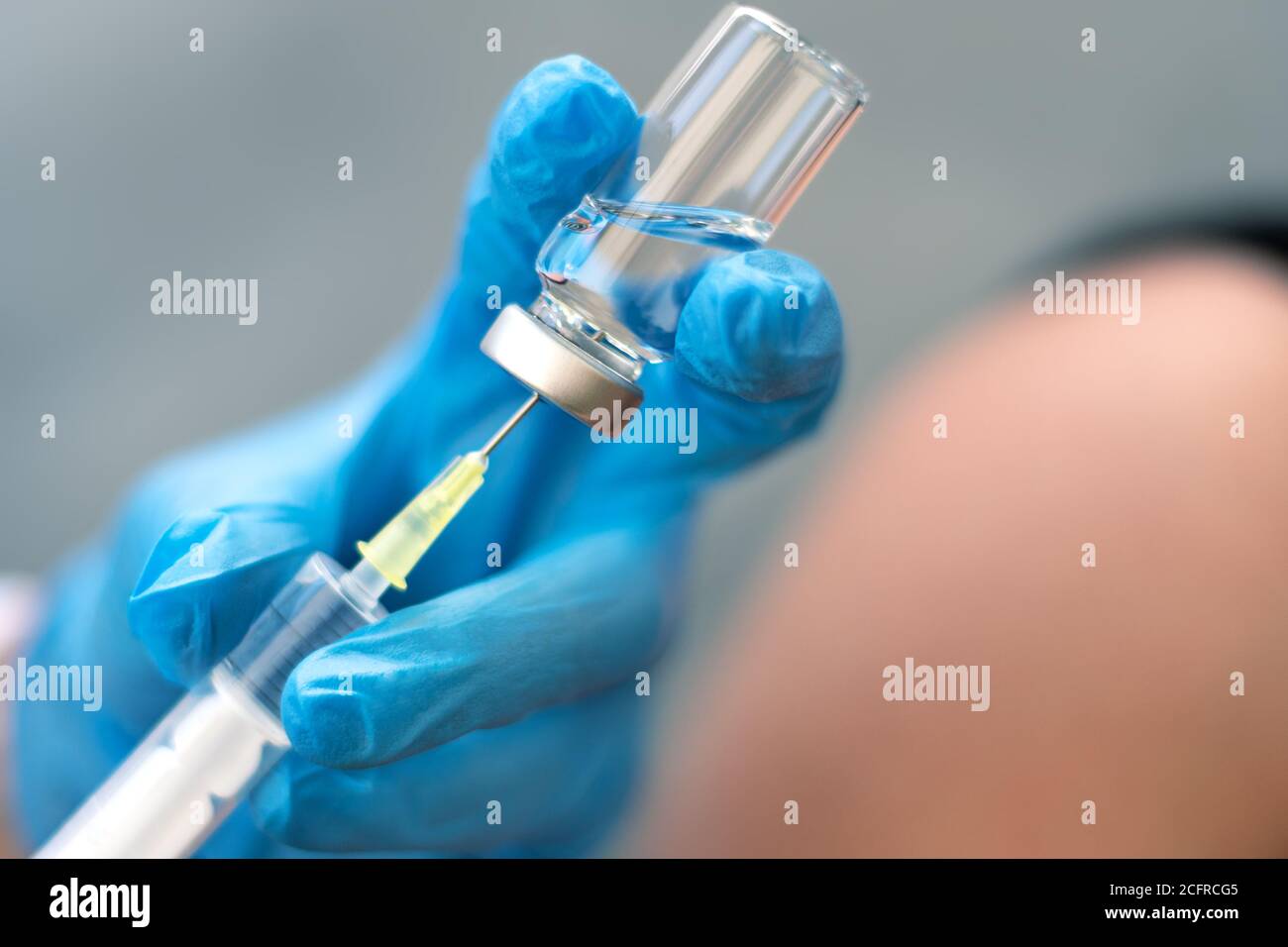 Biología y ciencia. Médico sosteniendo una jeringa, dando la vacunación. Alerta global. Vacunación. Gripe. Covid-19. Coronavirus. Investigación. Foto de stock