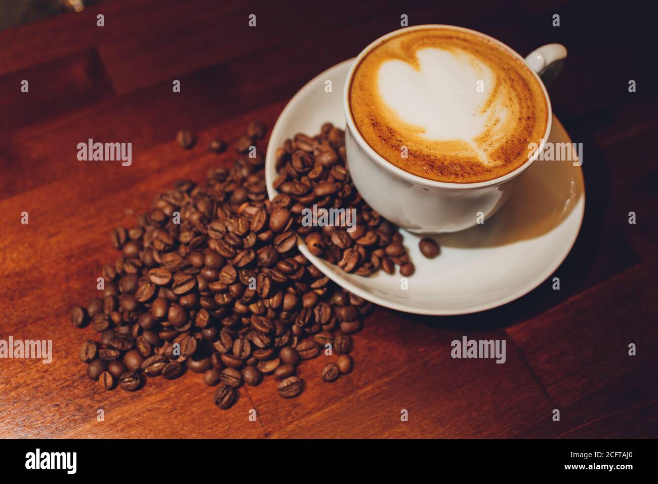 Capuccino con granos de café alrededor en taza transparente Stock Photo