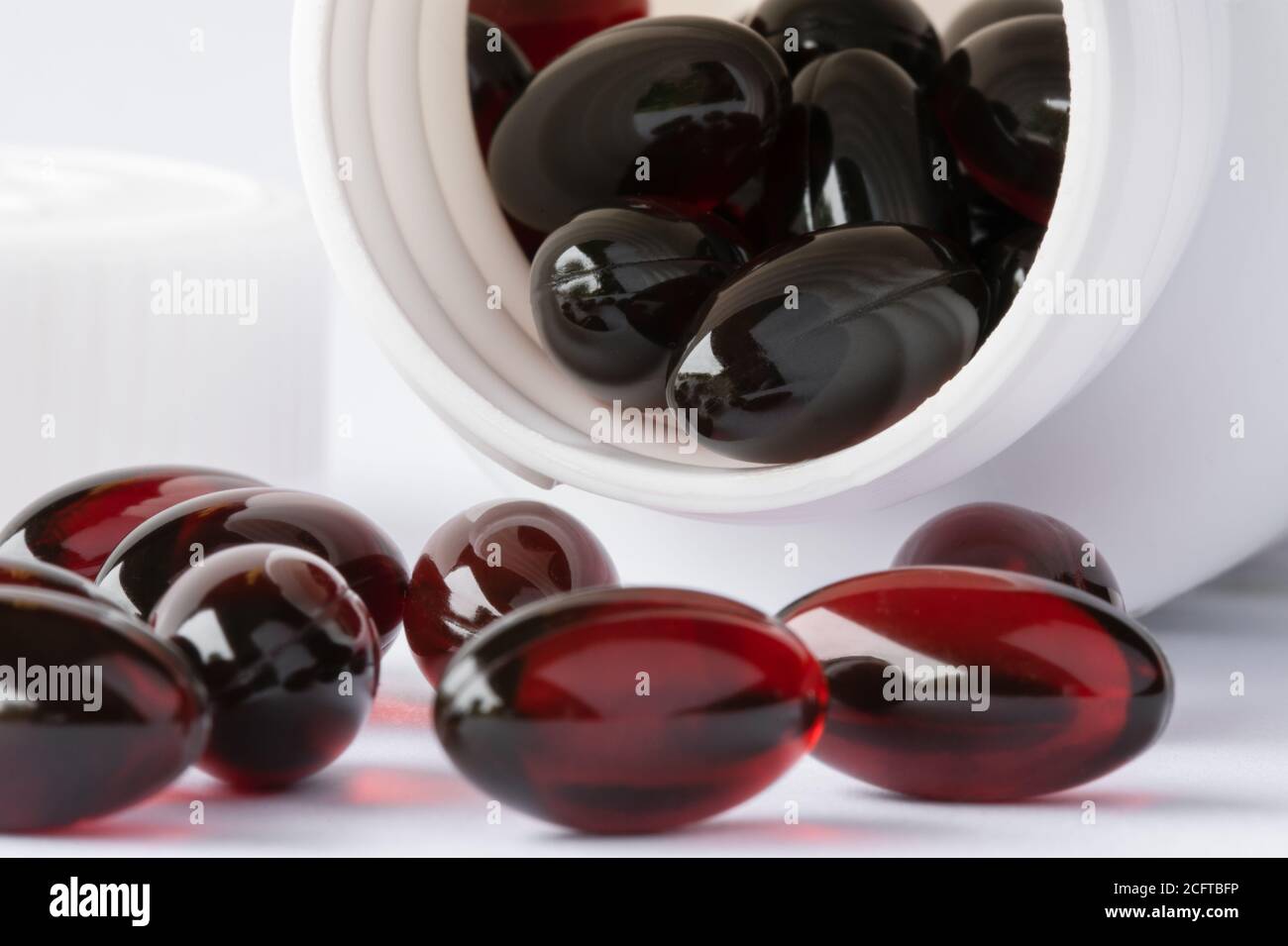 Cápsulas de aceite de krill derramadas de una botella Foto de stock