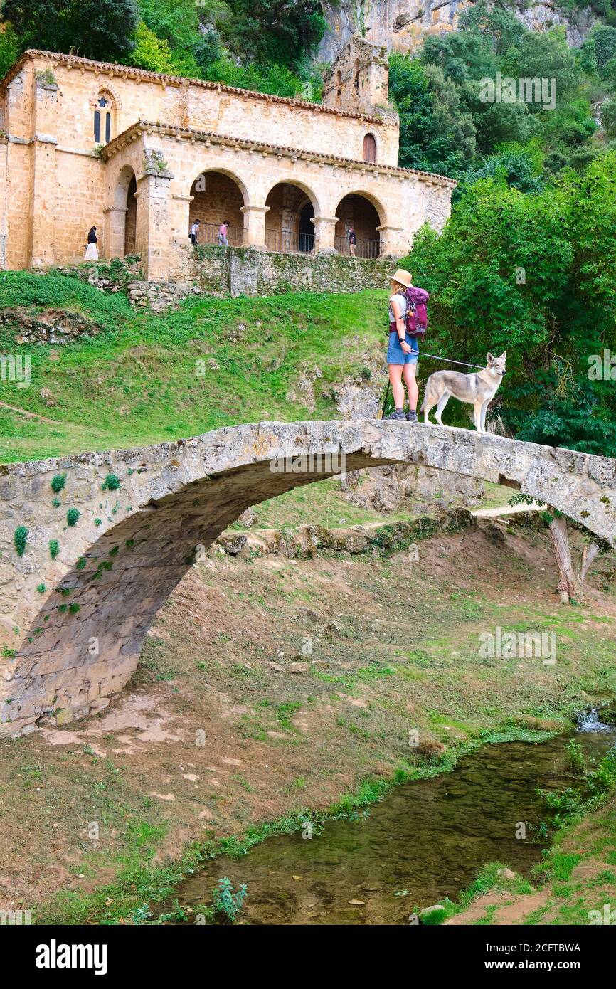 Antigua capilla, puente y una mujer turística con un perro. Foto de stock