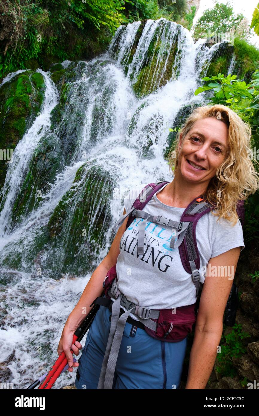 Hiker mujer joven madura y cascada. Foto de stock