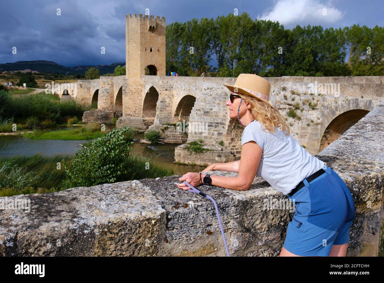 Mujer turística con un sombrero y puente medieval y el río Ebro. Foto de stock