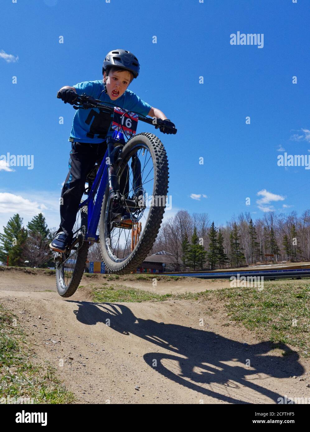 Un niño pequeño (8 años) saltando en su bicicleta de montaña Foto de stock