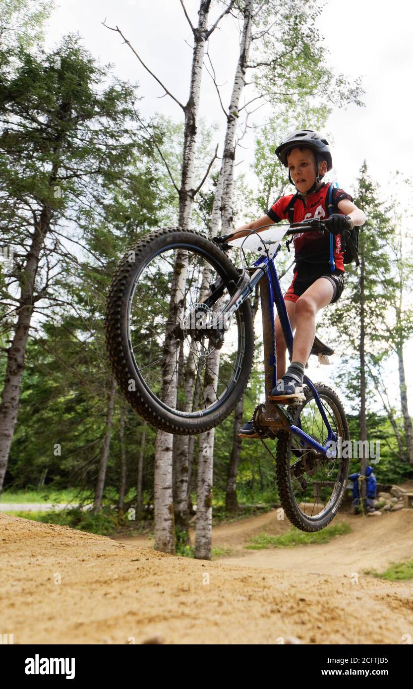 Un niño pequeño (8 años) saltando en su bicicleta de montaña Foto de stock