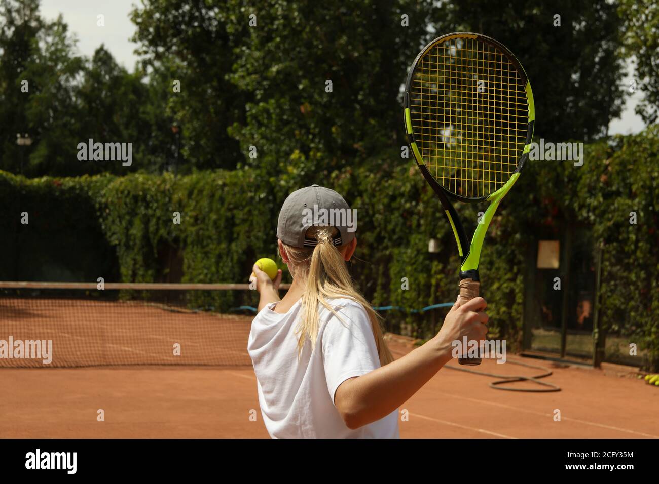 Mujer Cacausian en traje deportivo jugando al tenis al aire libre