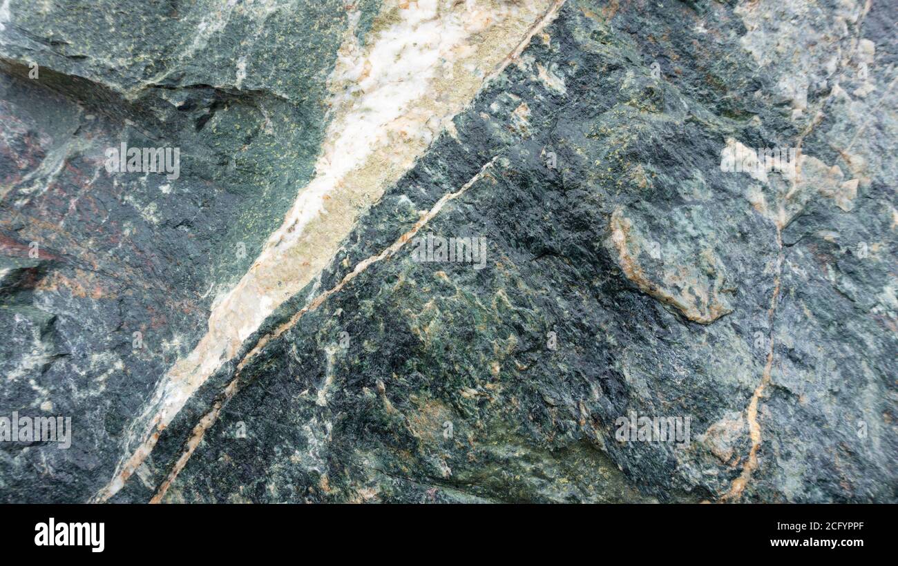 Fondo gris-verde abstracto con textura de piedra de la diabase de gabbro. Fondo de piedra de gabbro-diabase roca. Cantos rodados en diseño paisajístico. Foto de stock