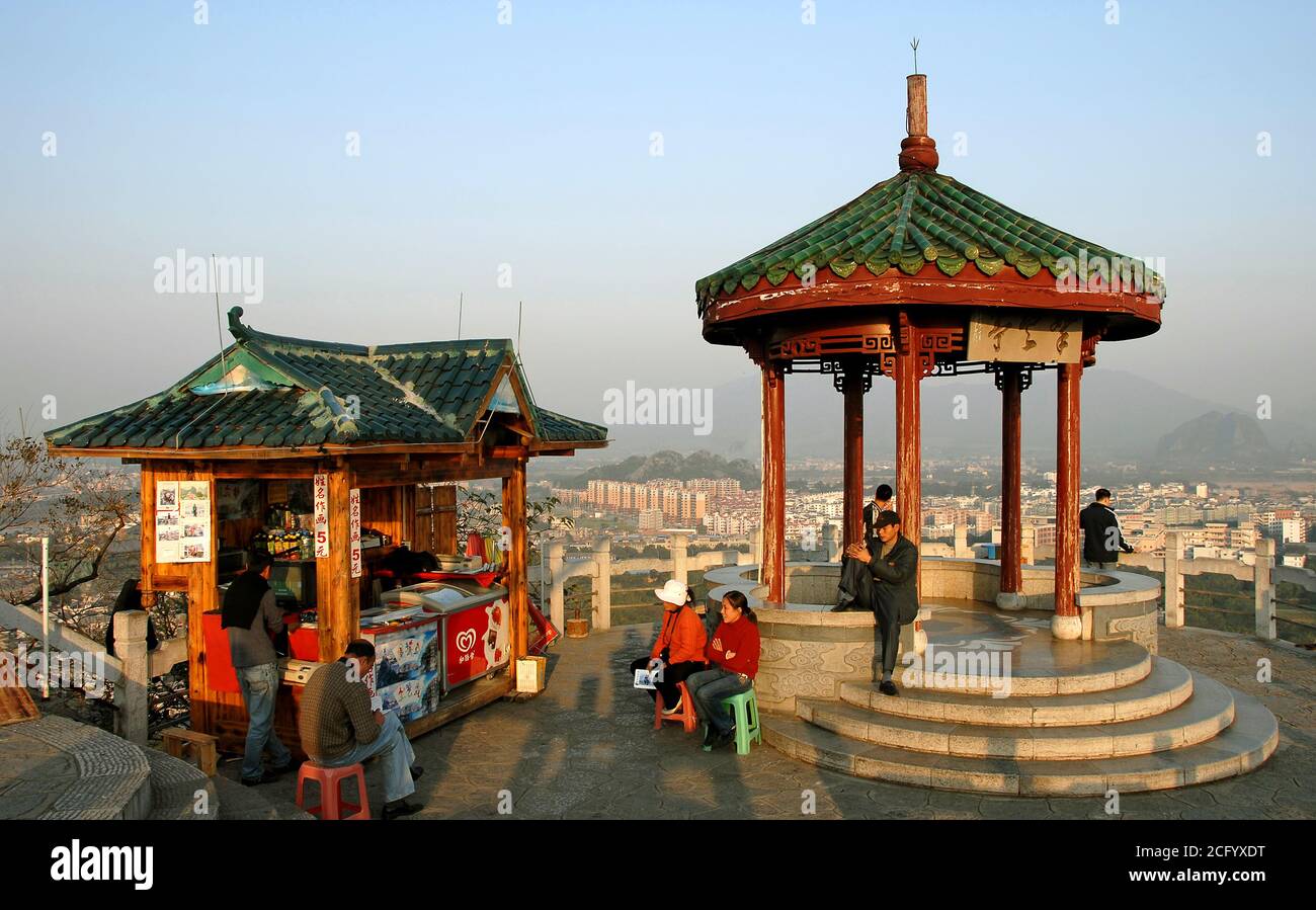 Monte Diecai, Guilin en la provincia de Guangxi, China. La cumbre del Monte Diecai con el pabellón de la cumbre y el quiosco. La gente disfruta de las vistas y del sol de la noche. Foto de stock
