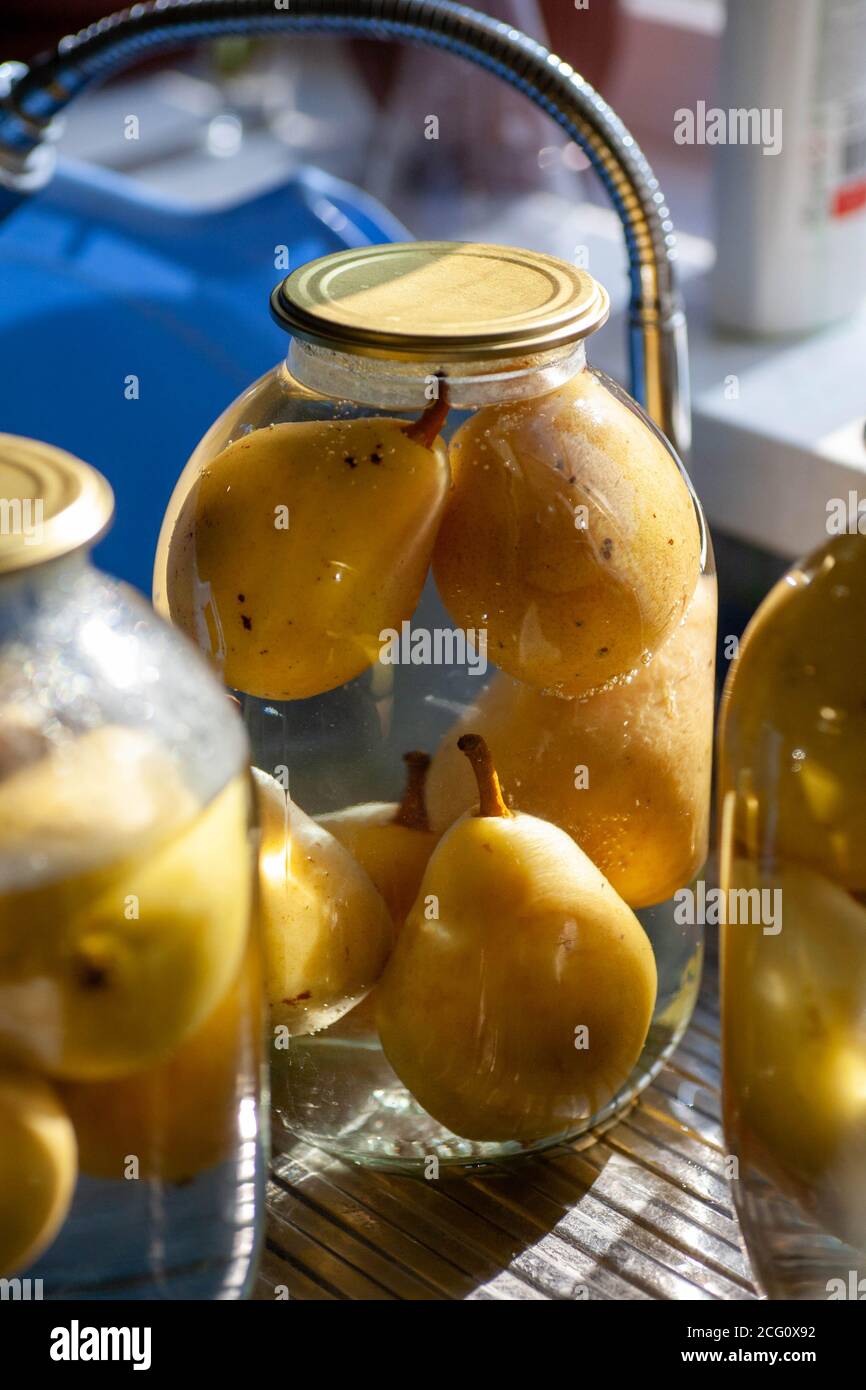 compota de pera. Peras enlatadas en una jarra de cristal. Suministros caseros de fruta para la serpiente. Foto de stock