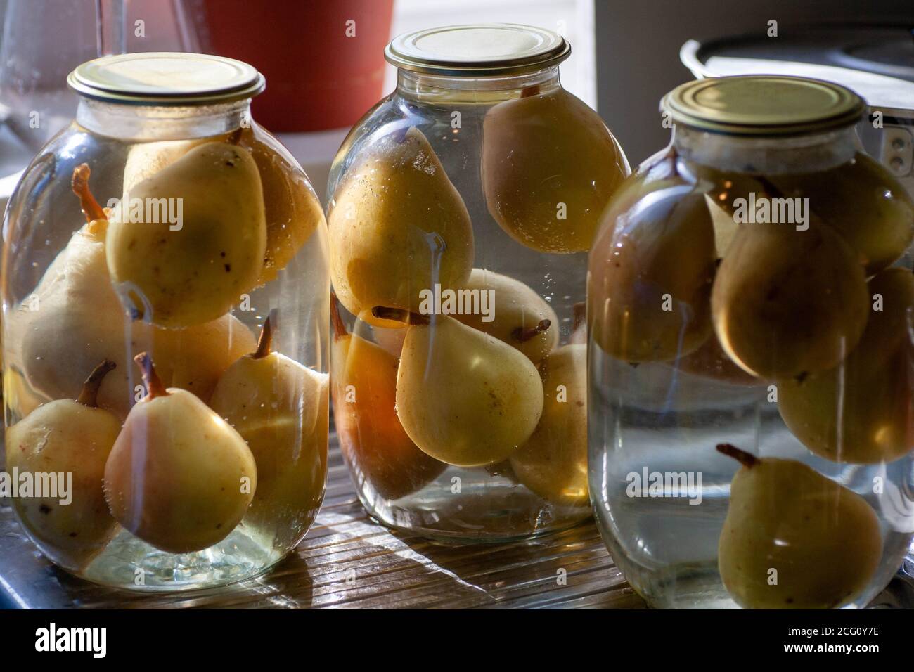 compota de pera. Peras enlatadas en una jarra de cristal. Suministros caseros de fruta para la serpiente. Foto de stock