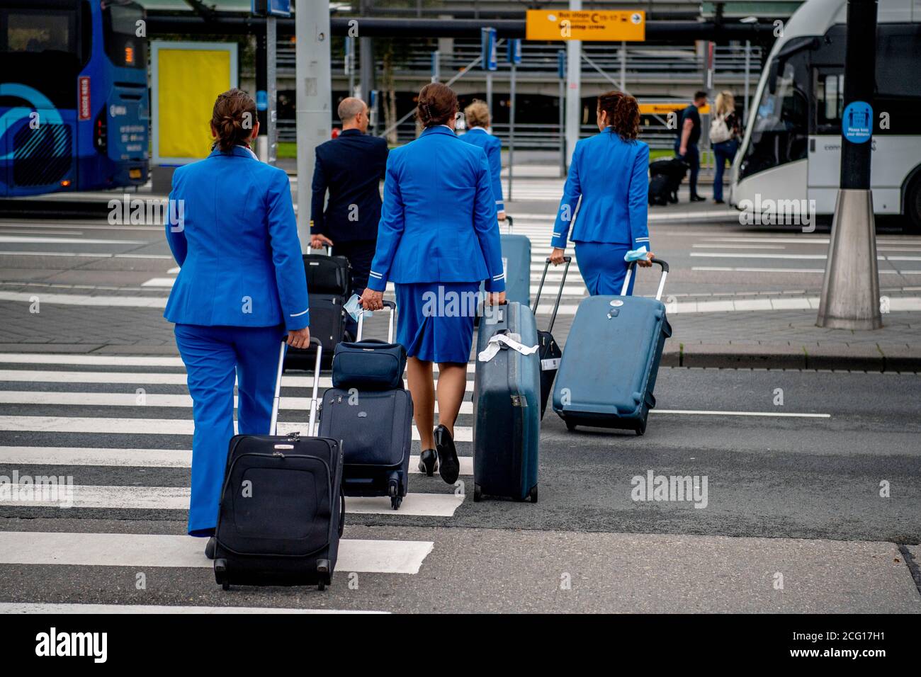 Auxiliares de vuelo y pilotos vistos con su equipaje.el aeropuerto de  Schiphol está ocupado de nuevo operando bajo medidas, ya que KLM recibe un  paquete de apoyo de 3.4 mil millones de