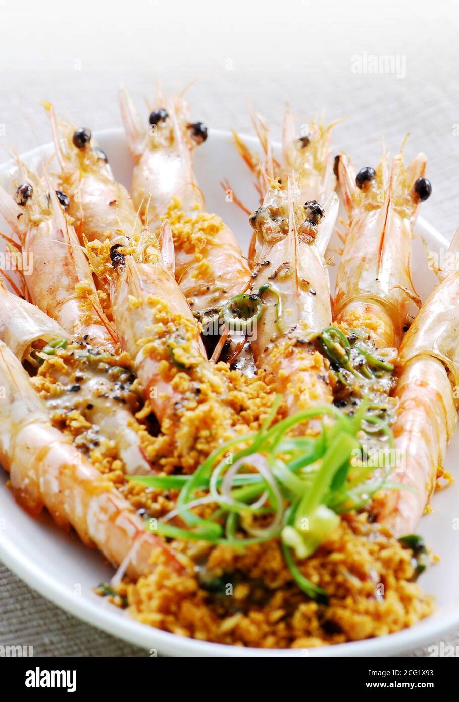Gambas fritas en un plato con ajo picado Foto de stock