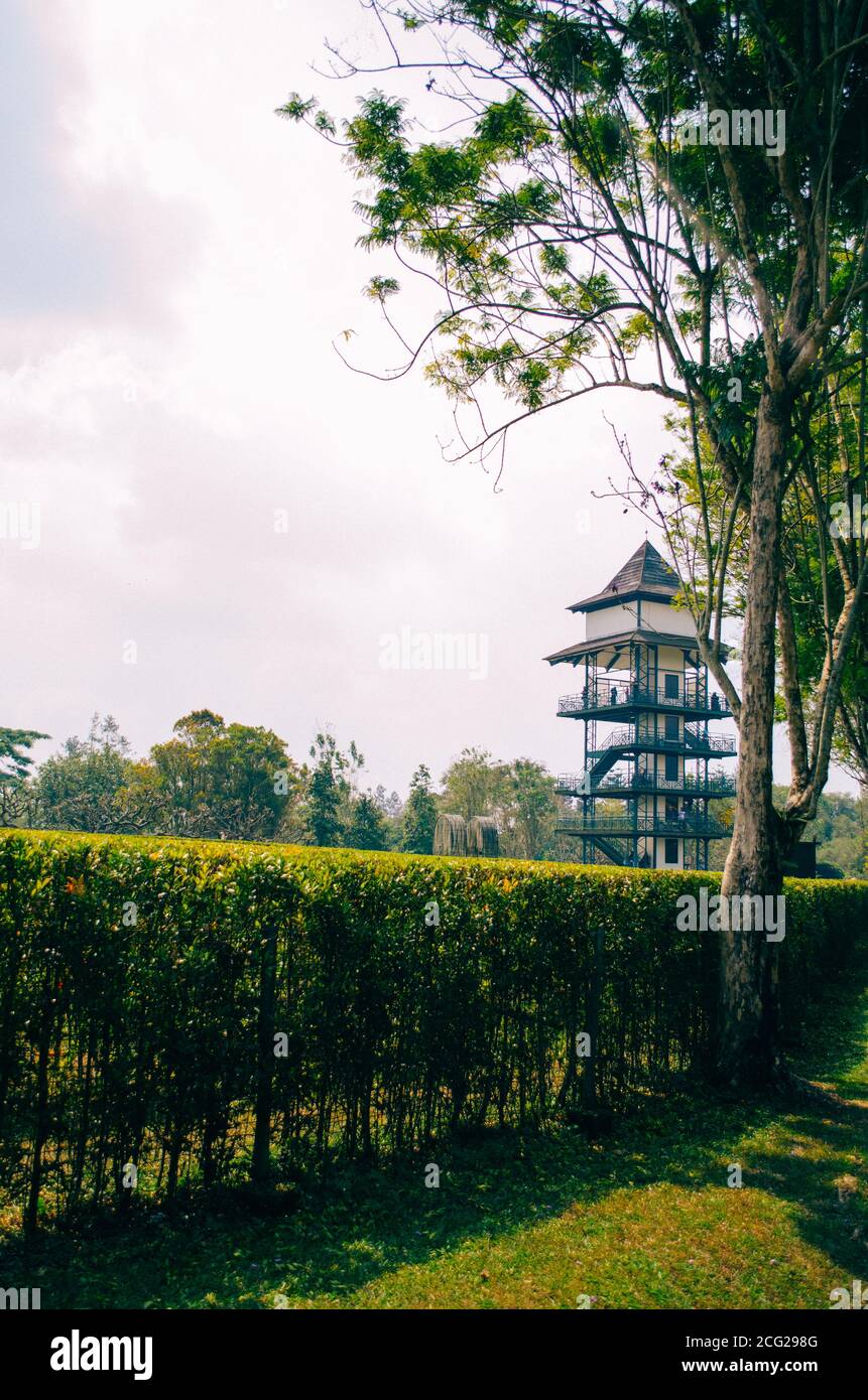 Bogor, Indonesia - una vista del parque temático de flores Taman Bunga Nusantara en una tarde nublada con una vista a una torre de observación en el lado derecho. Foto de stock